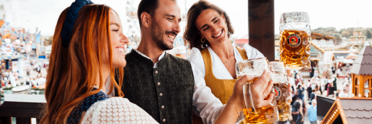 Gäste trinken PAULANER Oktoberfestbier auf dem Balkon des Festzeltes. Gäste trinken PAULANER Oktoberfestbier auf dem Balkon des Festzeltes.