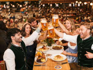Besucher im Paulaner Festzelt stoßen an: Ein Prosit der Gemütlichkeit!